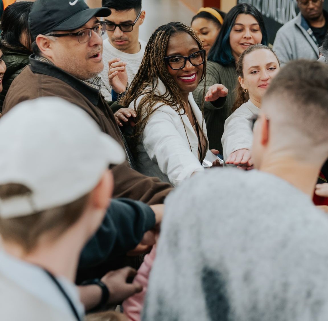 A diverse group of people in a joyful huddle at Movement Church